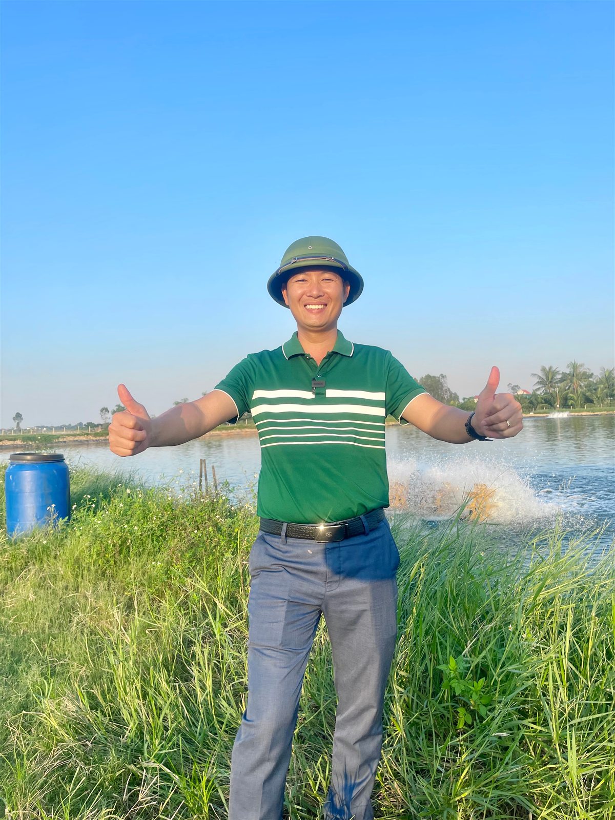 Dàn quạt nước chạy dọc bờ ao đất trong ao nuôi tôm