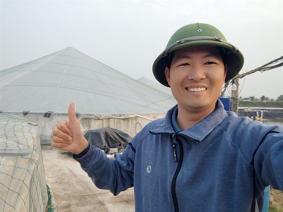 Nhận biết tảo độc trong ao tôm — anh Thiện đi kiểm tra màu nước khu ao nuôi có nhà lưới che